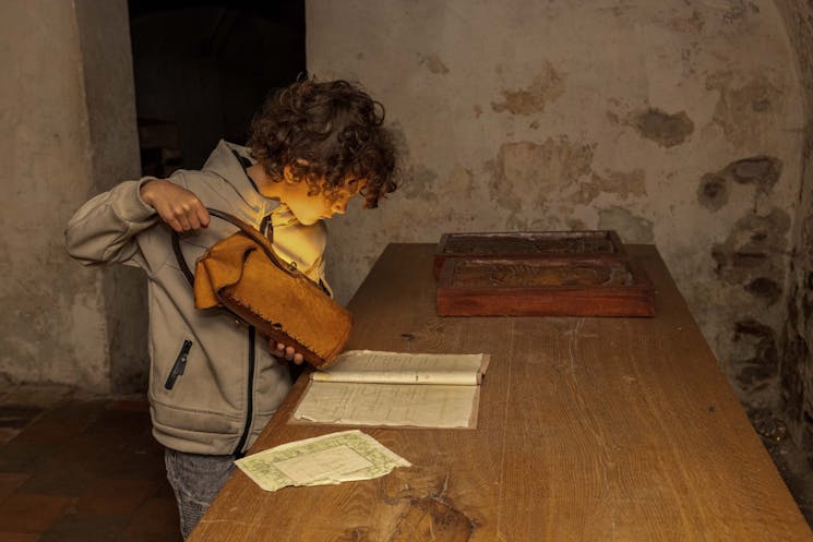 Kind houdt de pratende lantaarn vast in de kelder van kasteel Hernen