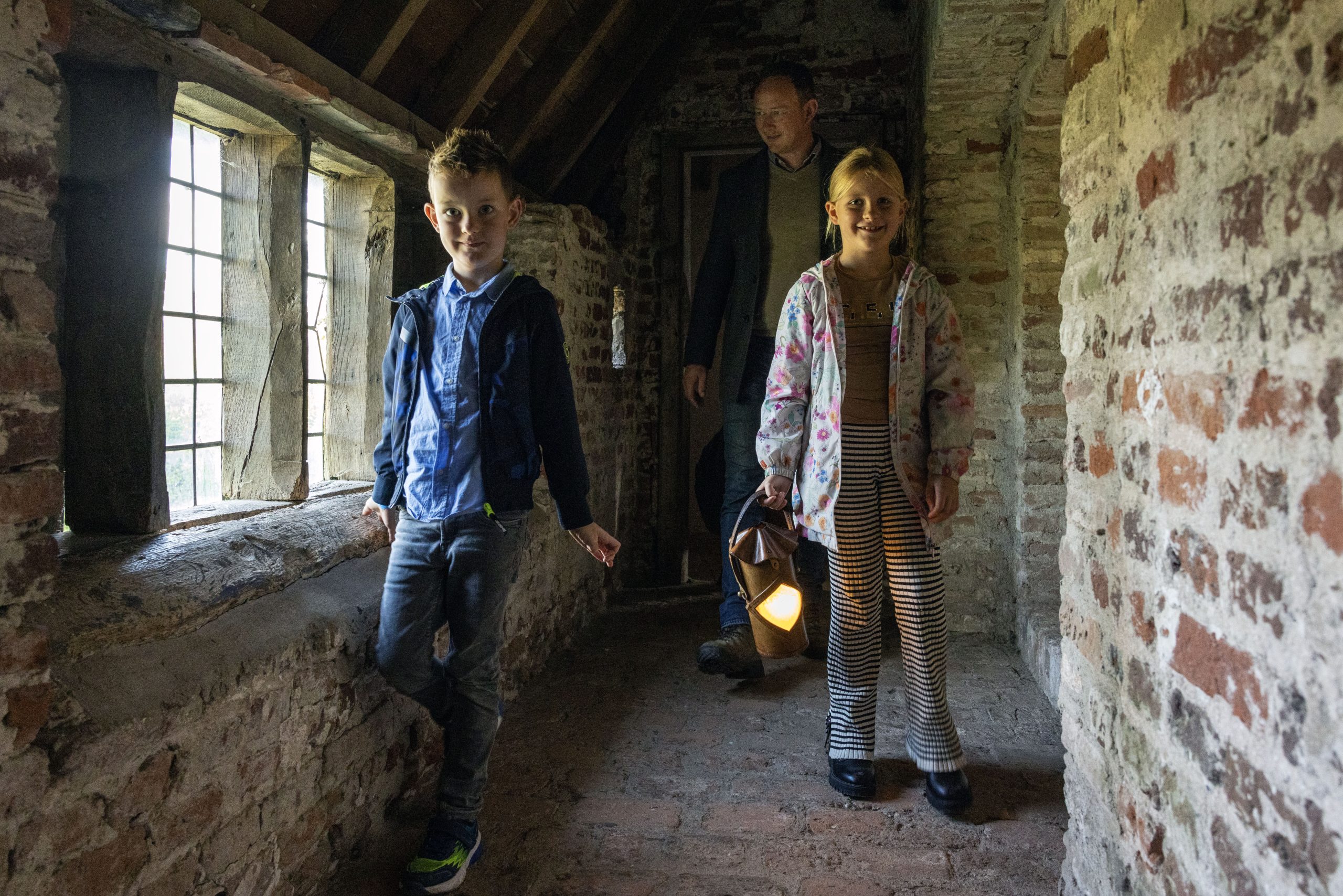 Kinderen met pratende lantaarn in de weergangen van kasteel Hernen
