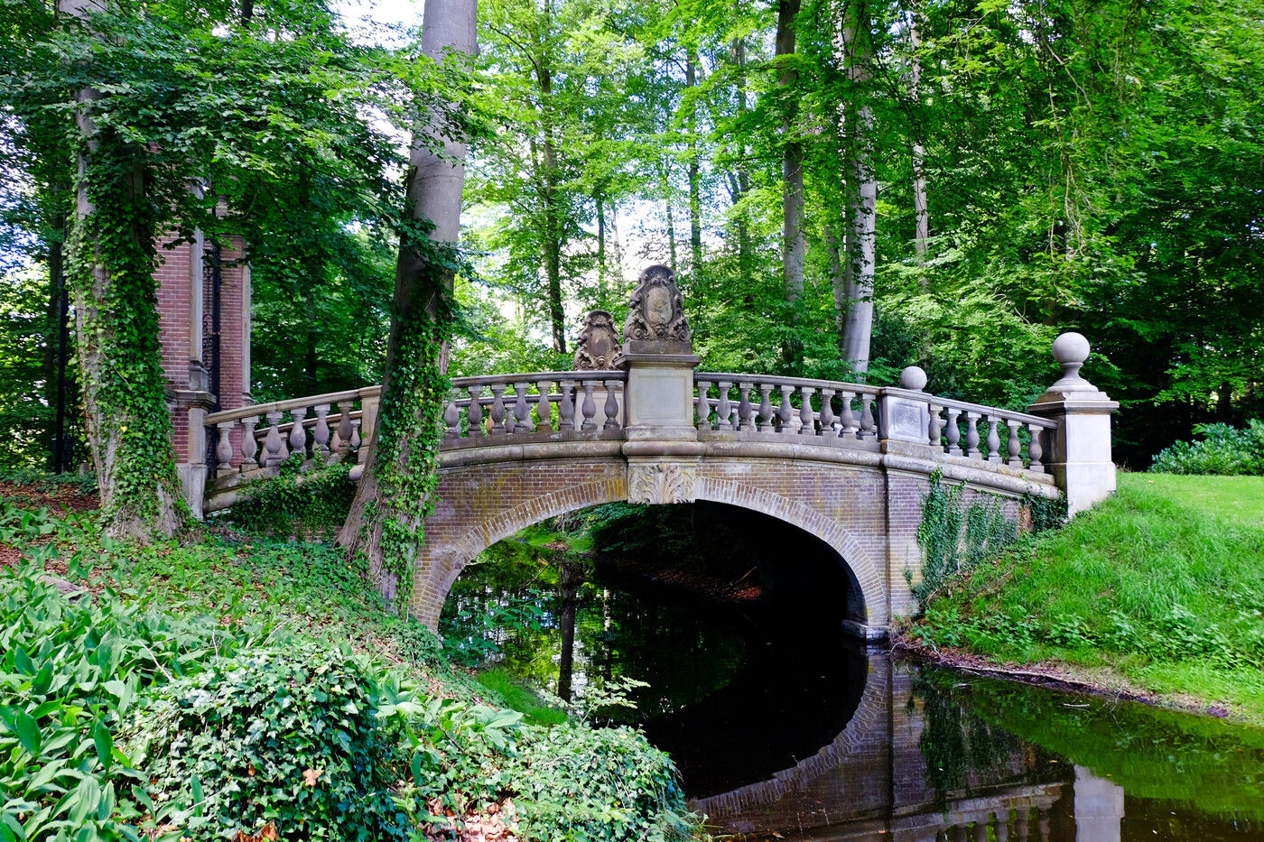 Monumentale brug met toegangshek omringd door bomen op landgoed De Ehze.