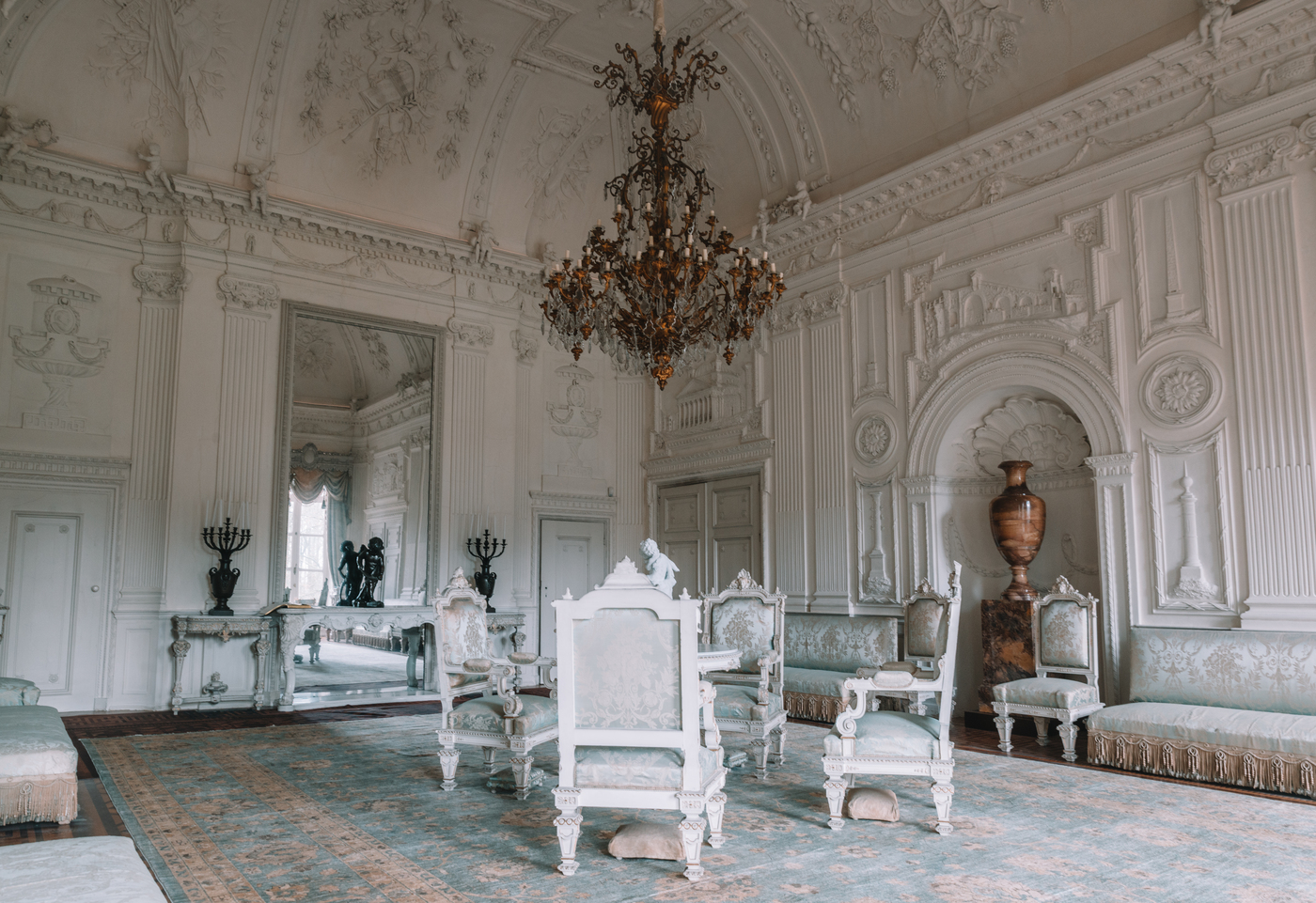 Kasteel Biljoen; witte stuczaal met kroonluchter en antiek meubilair