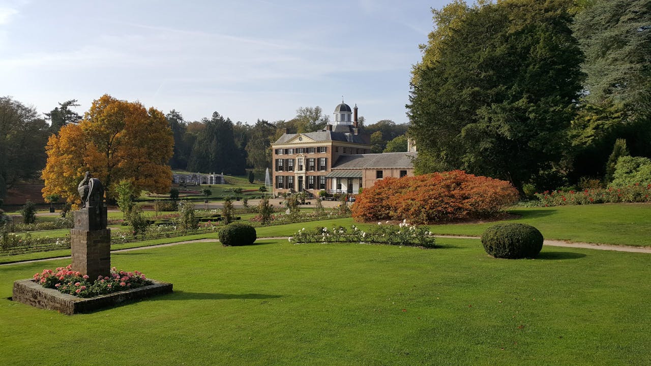 Herfsttinten in de Rozentuin van kasteel Rosendael, met uitzicht op Schelpengalerij en monument