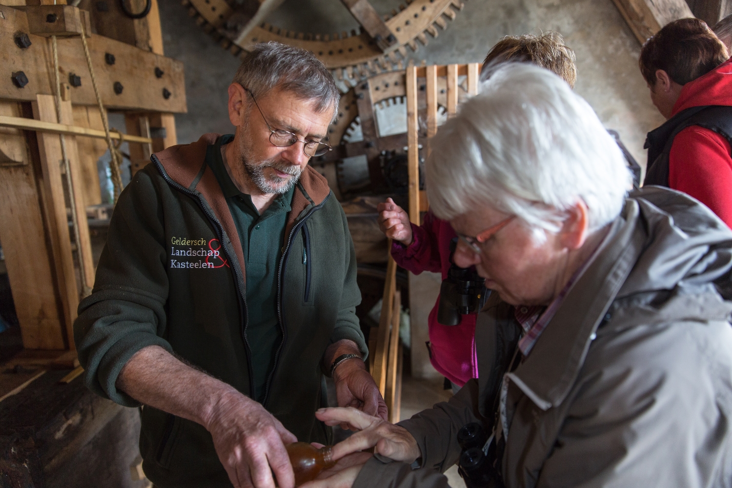 Een medewerker van Geldersch Landschap & Kasteelen ontvangt bezoekers in de oliemolen op landgoed Huis te Eerbeek.