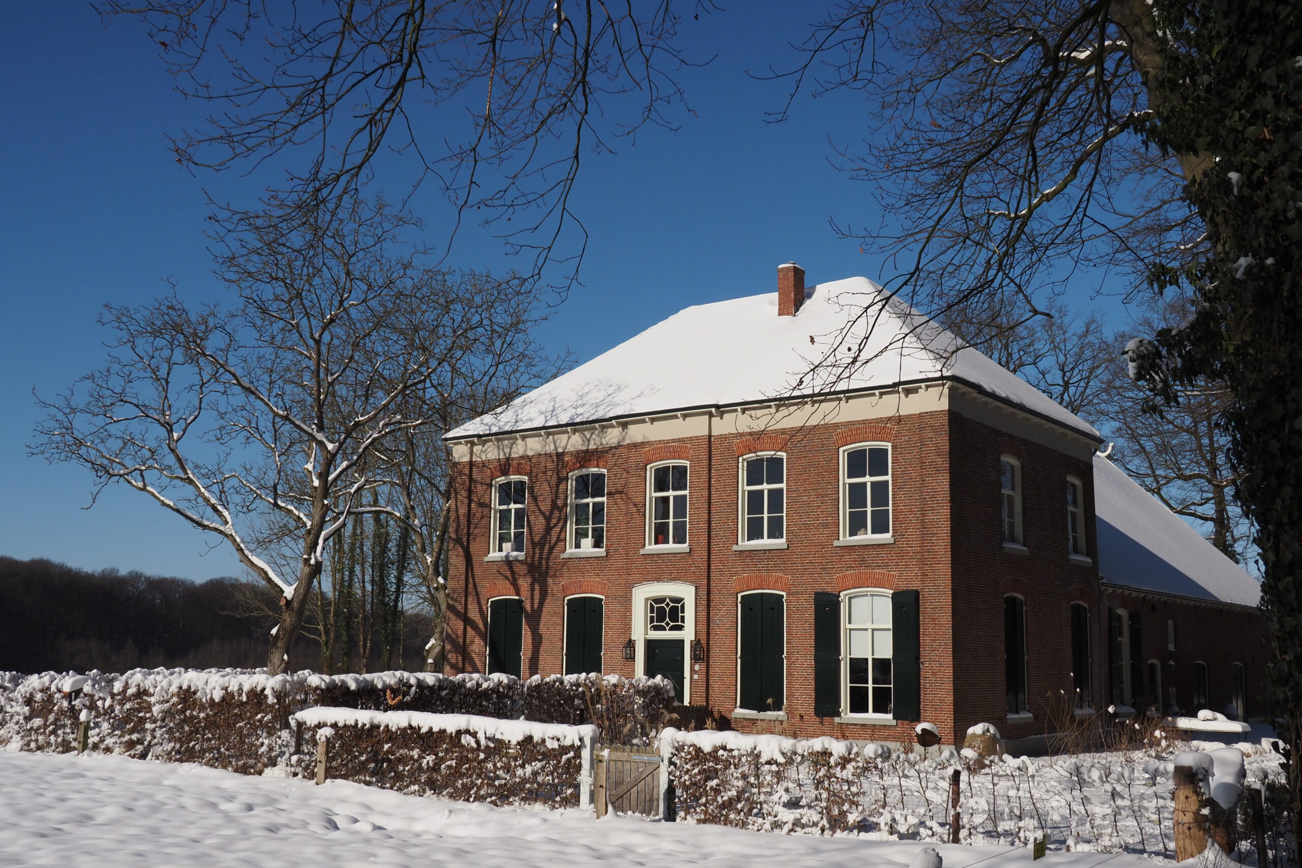 Scholtengoed Hijink; voorzijde van de boerderij in een winters sneeuwlandschap.