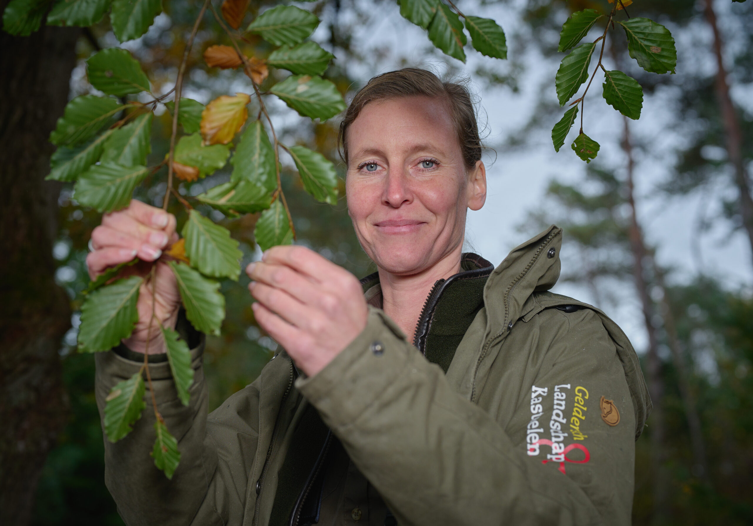 Een medewerker van Geldersch Landschap & Kasteelen, staand geportretteerd in het bos van De Dellen en Heerder Sprengen.