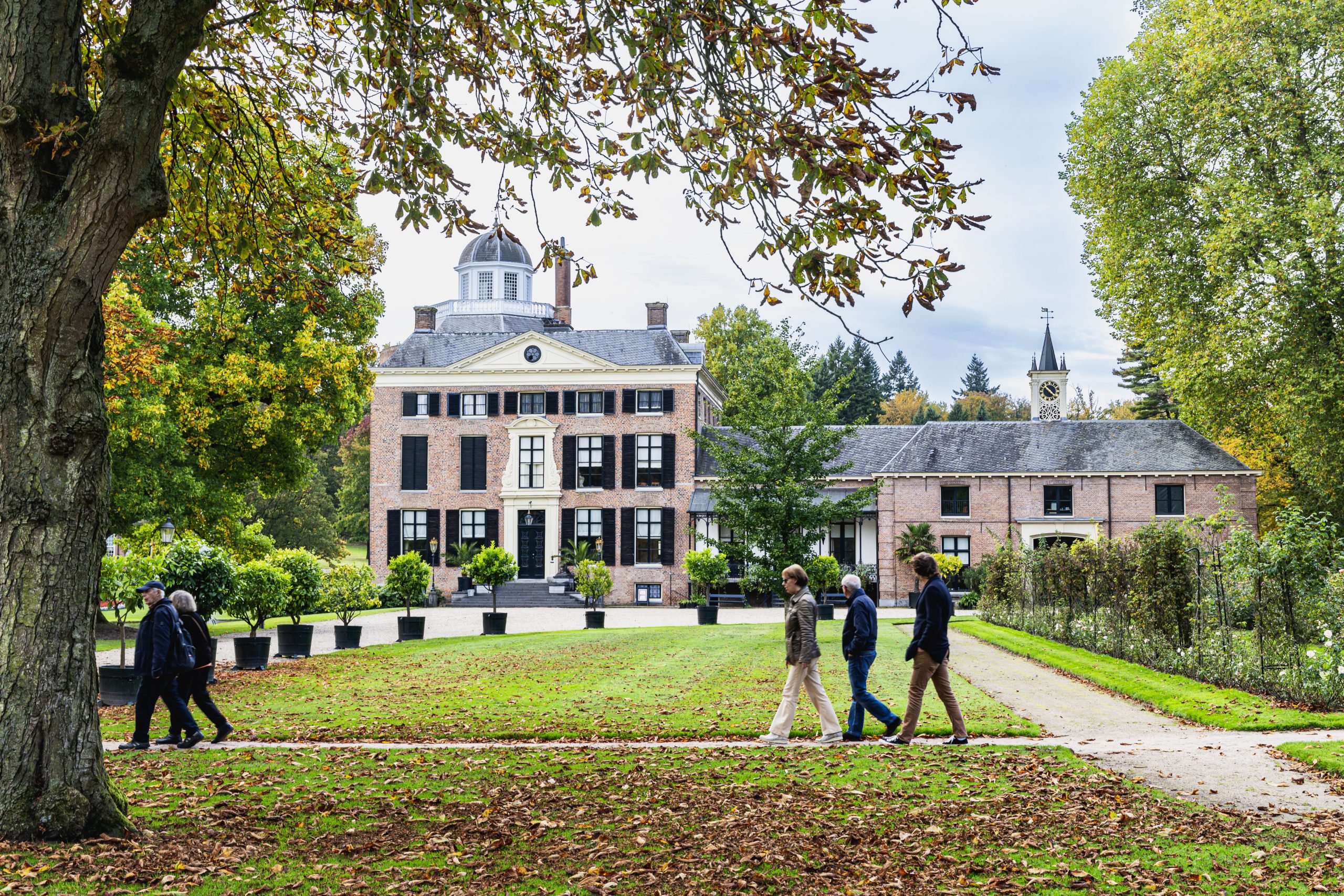 Bezoekers op het voorterrein met kuipplanten van kasteel Rosendael