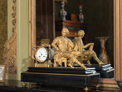 Klok staande op schouw van de derde salon