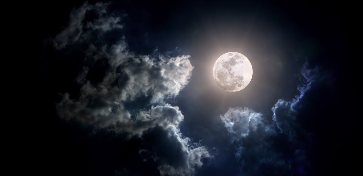 volle maan met wolken die aangelicht worden