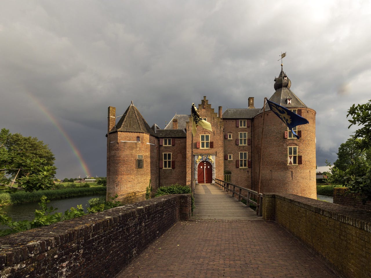 Kasteel Ammersoyen met donkere lucht en regenboog