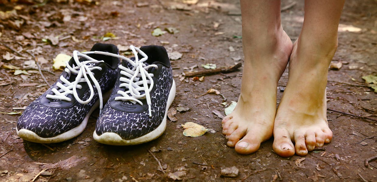 Blote voeten en een paar zwarte sneakers close up foto