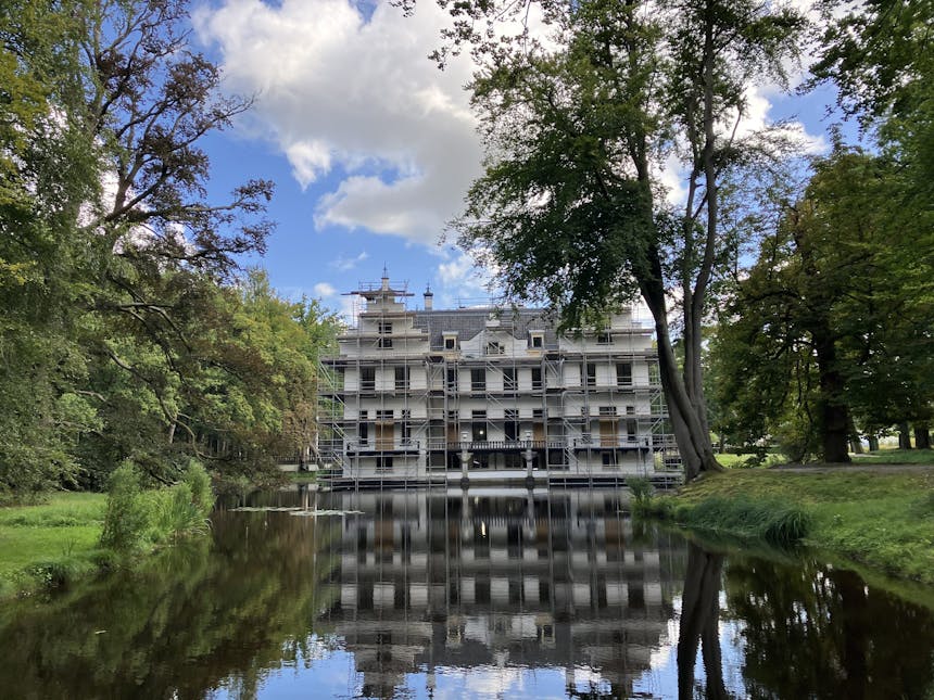 Kasteel Staverden in de steigers, gezien vanaf de achterzijde, met op de voorgrond de gracht.