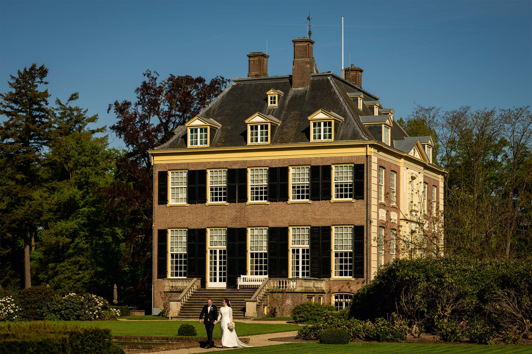 bruidspaar in de tuin bij Huis Verwolde