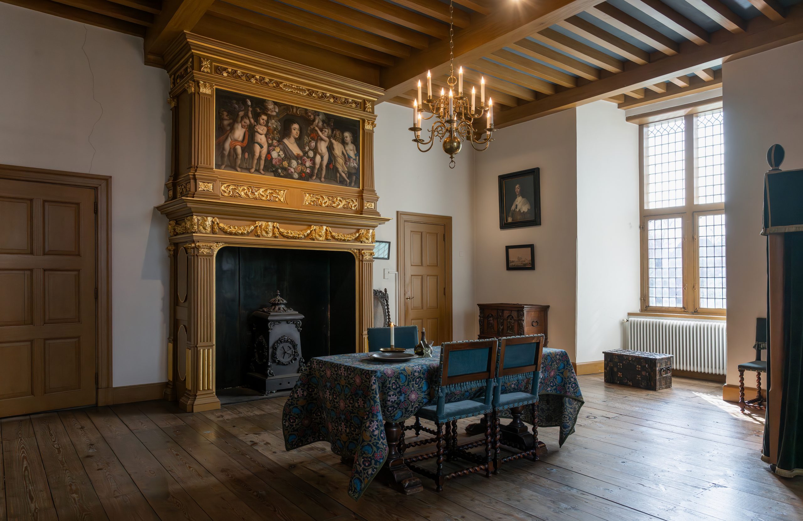Een ingerichte ruimte met tafel en rijk bewerkte haard op kasteel Ammersoyen